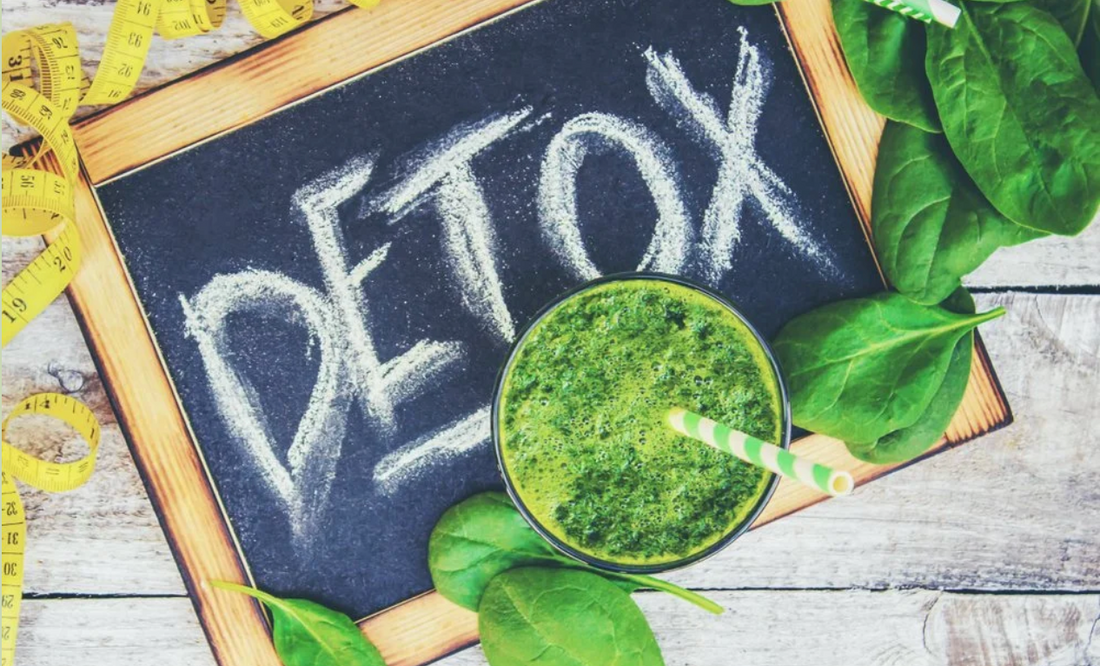 Detox green smoothie with chalkboard sign and fresh spinach leaves